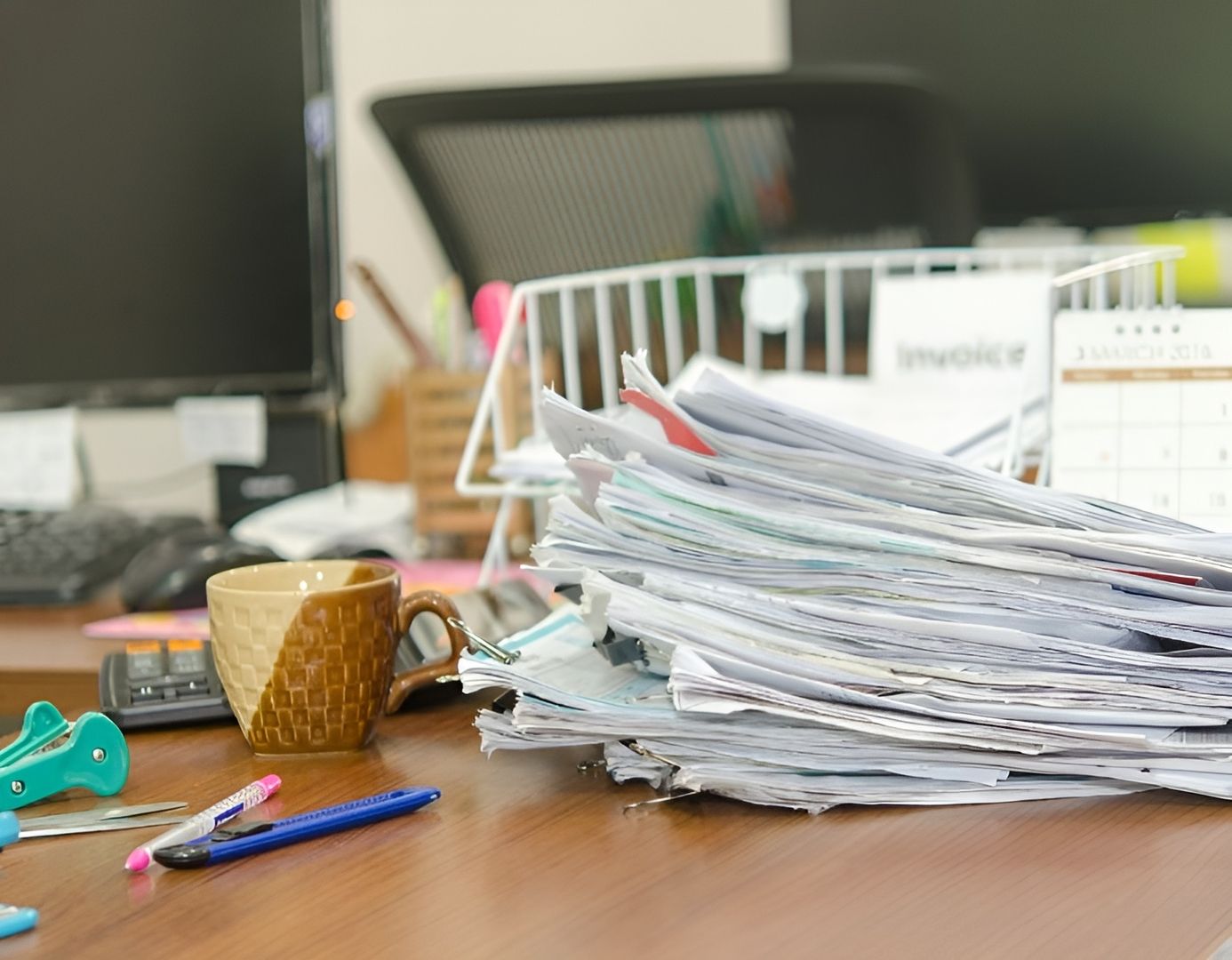 Ein Stapel von Papieren liegt auf einem Schreibtisch in einem Büro.